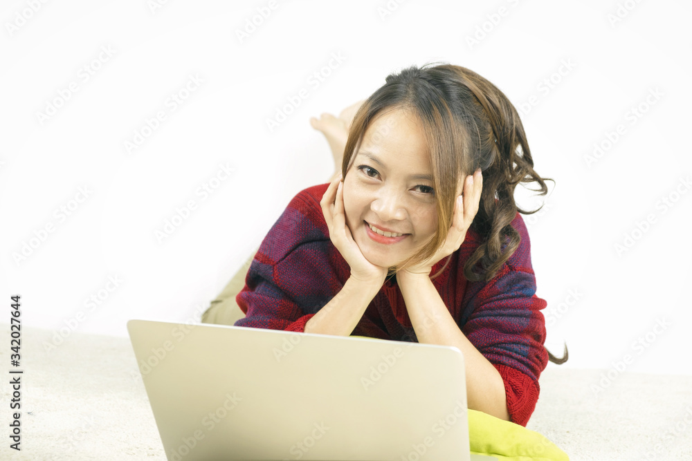 Asian woman smiling and lying on carpet with laptop at home. Work from home concept. Asian woman smiling and lying on carpet with laptop at home. Work from home concept.