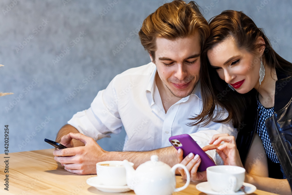 Couple drinking coffee laughing in cafe Couple drinking coffee laughing in cafe