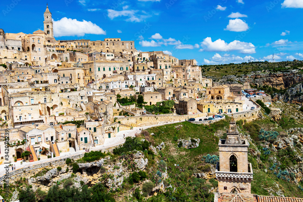 Scenic panoramic sunny summer view of Matera, Province of Matera, Basilicata Region, Italy. San Pietro Caveoso bell tower in the foreground