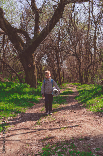 Solo traveller - young boy hiker in spring forest, goes on the path into the distance © Quatrox Production
