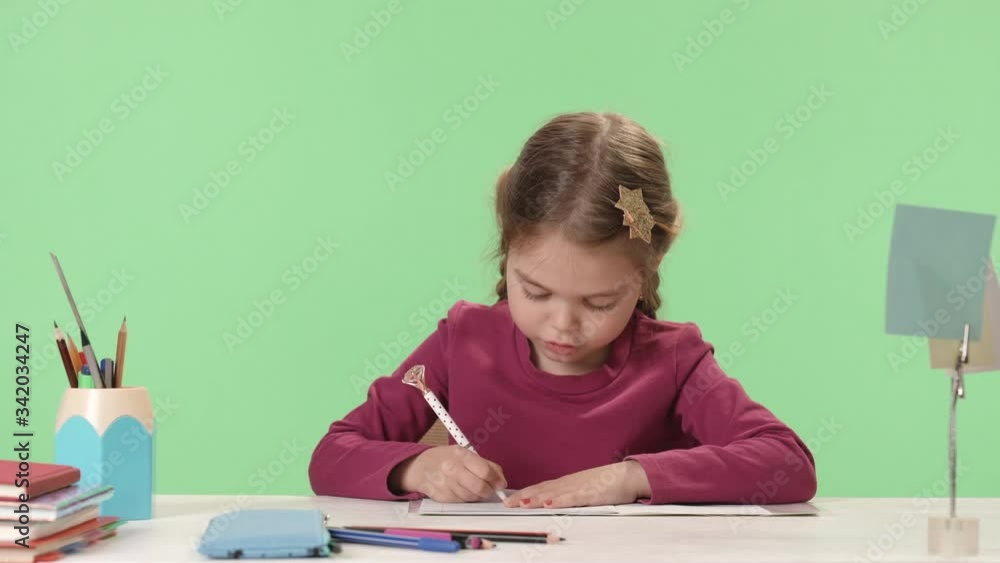 Young schoolgirl write in copybook, do homework. Cute caucasian tired cause stretches. E-education, learning during quarantine. Сoncept of rest while studying, online learning. Chroma key Young schoolgirl write in copybook, do homework. Cute caucasian tired cause stretches. E-education, learning during quarantine. Сoncept of rest while studying, online learning. Chroma key