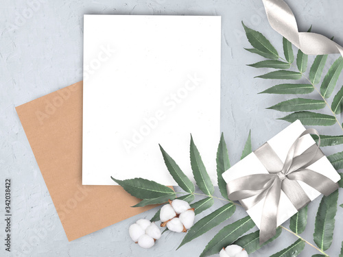 Mock up concept  with empty blank  envelope  gift  cotton flowers and leaves on grey background. Elegant still life flatlay for Mothers day  Womans day or wedding invitation.