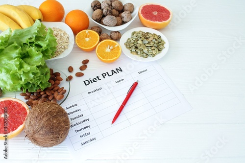 Healthy food and planning for diet. Clean eating selection: vegetable, fruit, seeds, nuts, superfood, cereals, leaf vegetable on white wooden background copy space