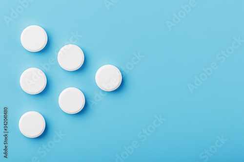 Round medicinal tablets in the shape of a triangle on a blue background, isolate.