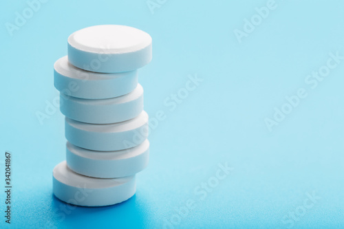 Round medicinal pills tower on a blue background, isolate.