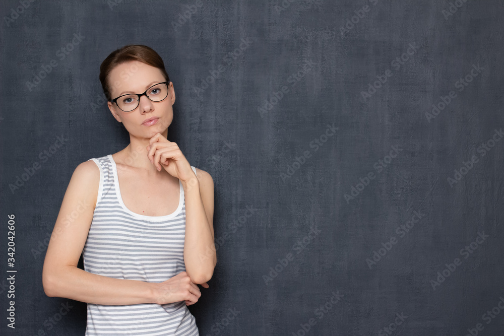 Portrait of focused girl with glasses, touching chin with hand Portrait of focused girl with glasses, touching chin with hand