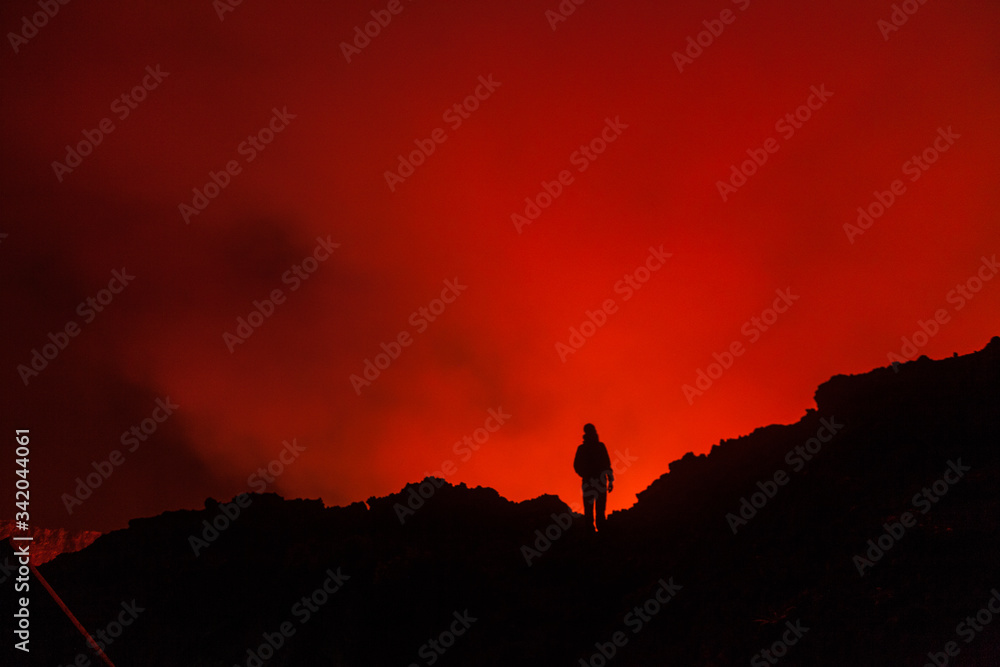 A tourist standing at the egde of the crater of volcano in Virunga National Park
