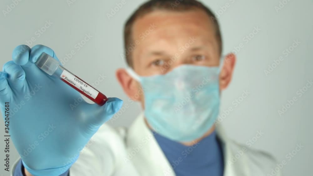 Medical lab worker with protective gloves holding test blood samples at the hospital, Doctor holding a test tube with a positive coronavirus test blood sample. New Coronavirus (2019-ncoV) Medical lab worker with protective gloves holding test blood samples at the hospital, Doctor holding a test tube with a positive coronavirus test blood sample. New Coronavirus (2019-ncoV)