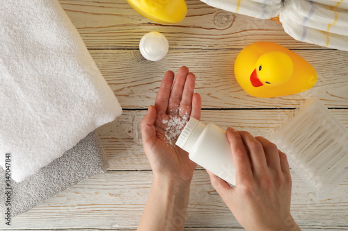 Mom applying talc powder from plastic tube. Baby hygiene