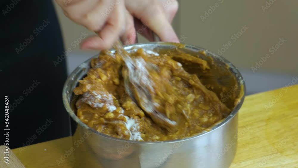 Close up of woman hands preparing peanut filling in a bowl for a cake. Close up of woman hands preparing peanut filling in a bowl for a cake.