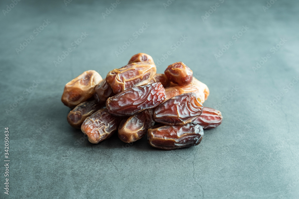 Fototapeta premium Raw date fruit ready to eat on concrete background. Traditional, delicious and healthy ramadan food.