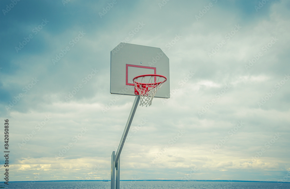 Basketball hoop against a cloudy sky in a Park on the beach