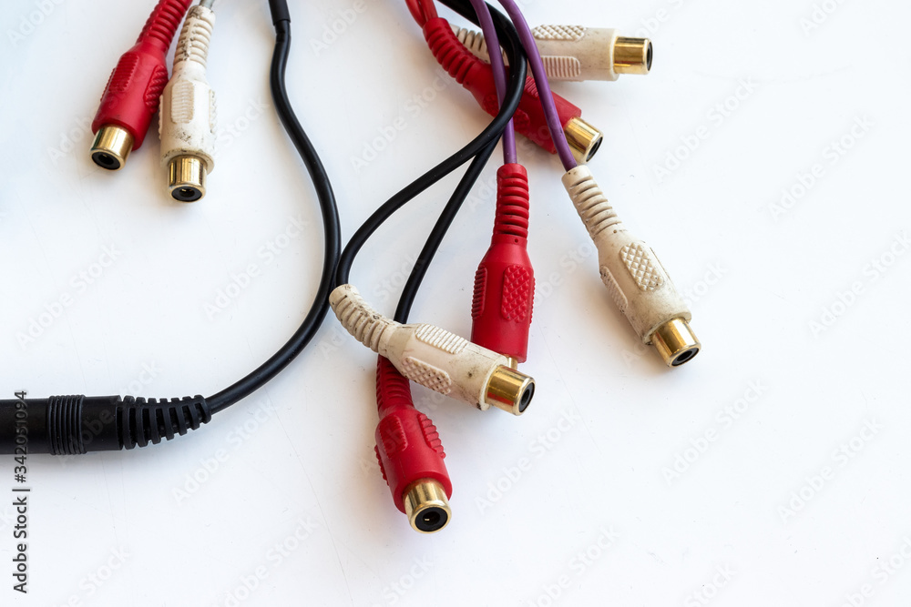 Dirty wires with black, red and white audio video connectors RCA jack on a white scratched work table Dirty wires with black, red and white audio video connectors RCA jack on a white scratched work table