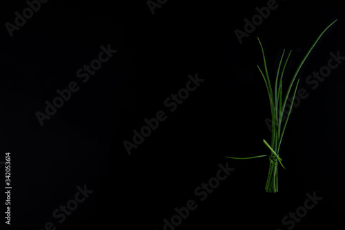 Green onions isolated on a black background, top view