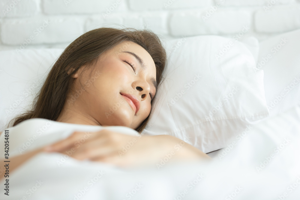 Beautiful woman sleeping on white bed in the bedroom,sweet dreams, keeps eyes closed, enjoys good rest at home and calm atmosphere. People and rest concept. Beautiful woman sleeping on white bed in the bedroom,sweet dreams, keeps eyes closed, enjoys good rest at home and calm atmosphere. People and rest concept.