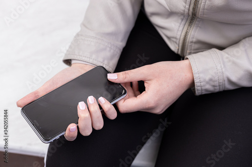 Girl with beautiful nails holds mobile phone with black screen
