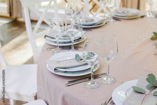 Festive table at the restaurant is decorated with eucalyptus flowers. Wedding reception dinner.