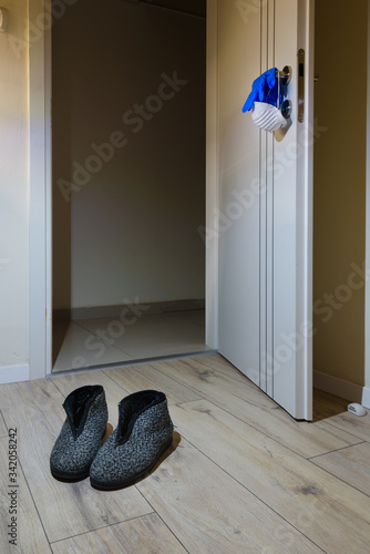 Coronavirus pandemic essentials:  When going out, not to forget the mask and gloves that are on the doorknob. At coming home, there are the slippers wait there…