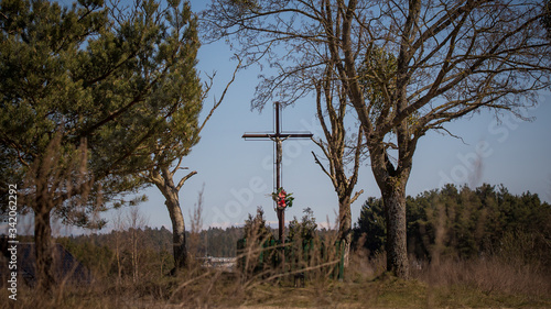 krzyż kapliczka przy drodze na wsi między drzewami