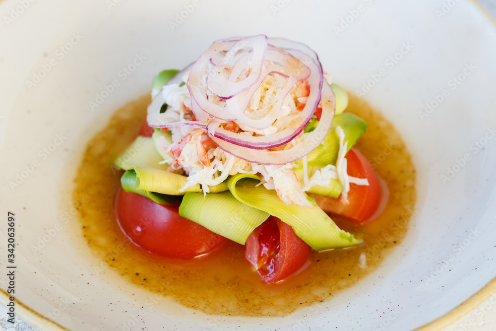 Fresh salad with crab meat and avocado in a plate.