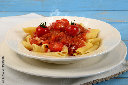 tomato sauce on penne pasta and small tomatoes