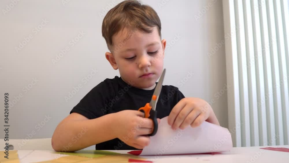 Male Primary School Cutting Out Paper Shapes In Craft Lesson Male Primary School Cutting Out Paper Shapes In Craft Lesson