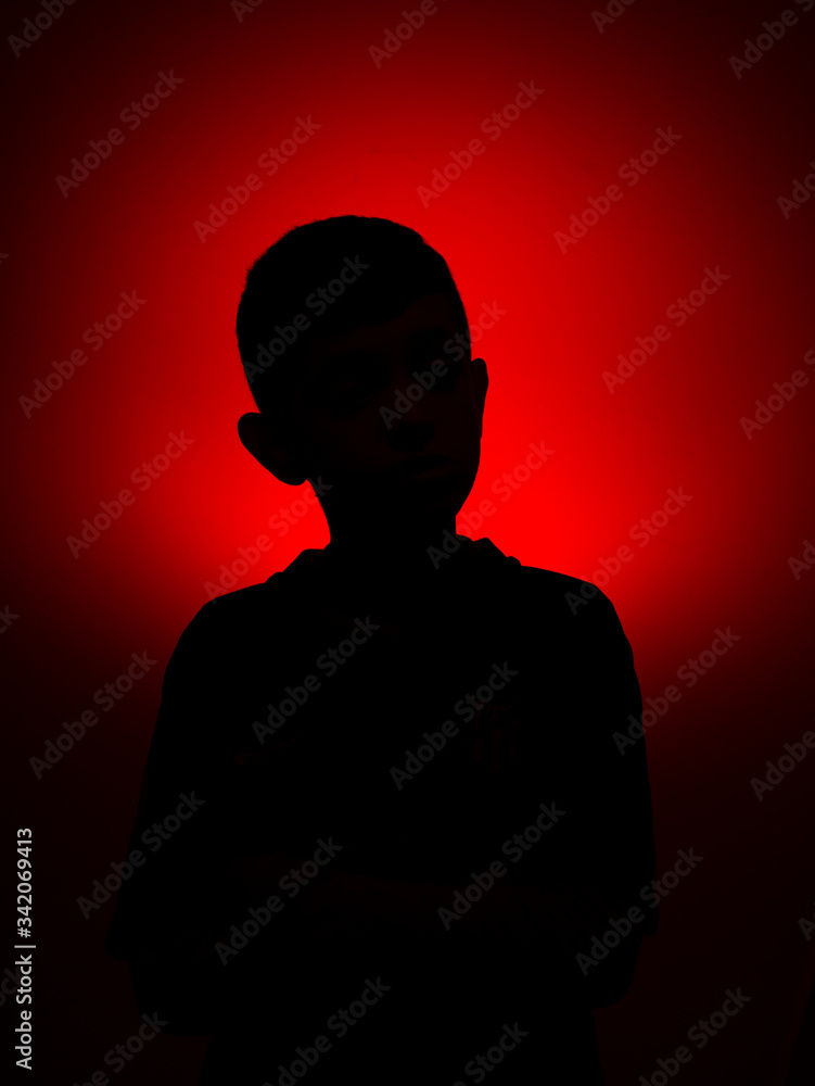 silhouette of a young boy on a red light