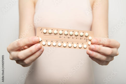 Girl holds birth control pills in her hands. Contraception