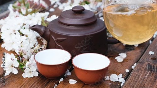 Chinese tea ceremony composition on wooden background with cherry leaves photo