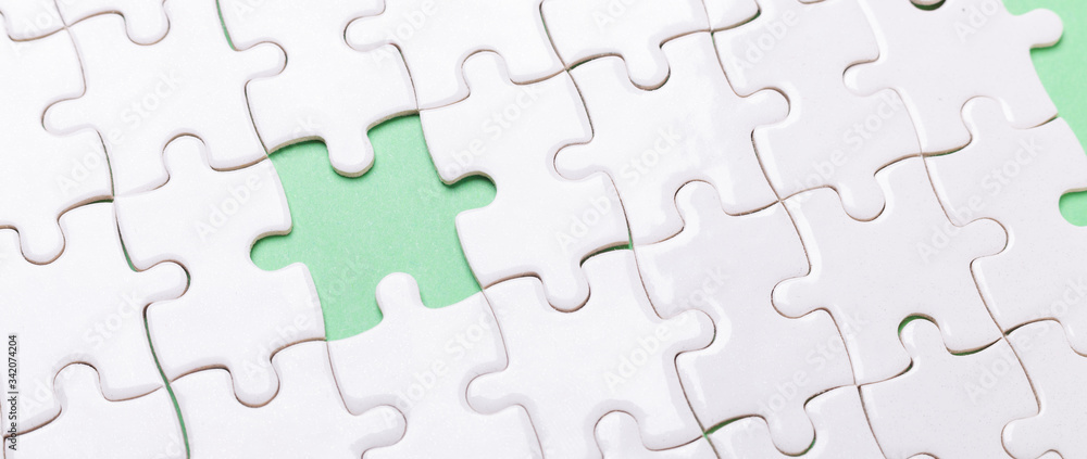 White puzzle background with one piece missing. Close-up. Concept success of business White puzzle background with one piece missing. Close-up. Concept success of business