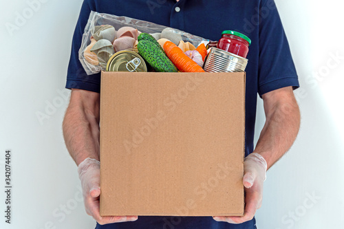 Male volunteer is holding a food donation box for people suffering from the effects of the coronavirus pandemic.