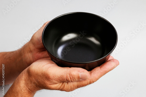 Man holds an empty bowl in his hands.