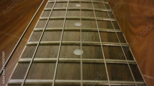 A 4K close up shot of a Banjo, guitar, Musical instrument, strings ready to be picked up and played. Learn a new instrument. Learn something new. Tilting shot