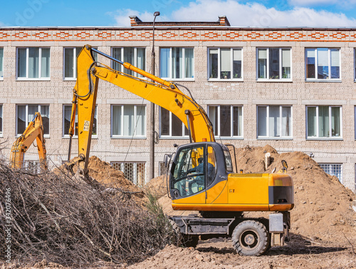 Excavator digs a hole on the construction site.