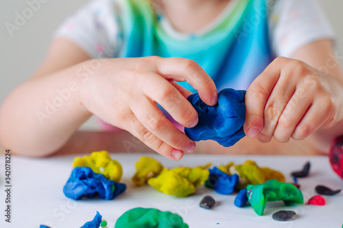 Close up of kids hands molding colorful childs play clay photo