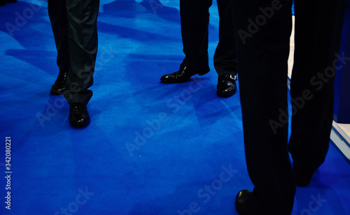 Business Men in Suits Standing on a Blue Carpet