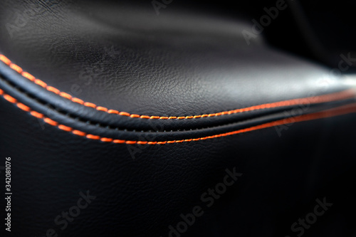 Detail of black and red line leather luxury car seat. Soft focus for texture background.
