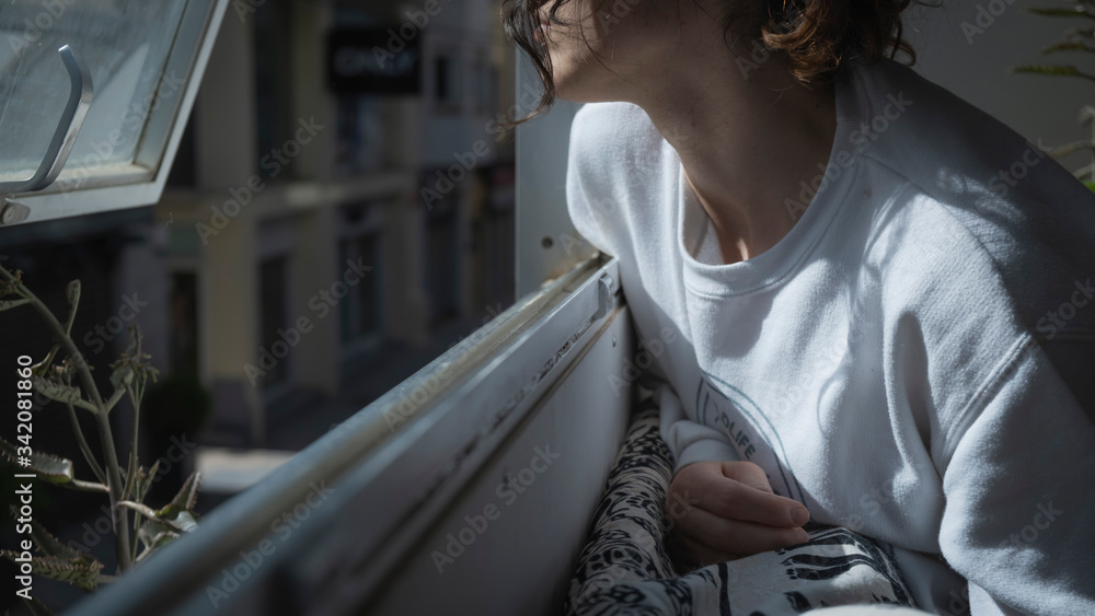 Chica con pelo rizado mirando por la ventana - obrazy, fototapety, plakaty 