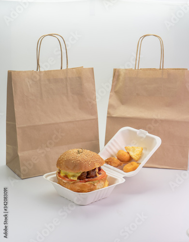 fast food delivery eco packaging and paper bag with a large delicious Burger.