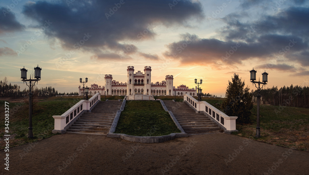 Kosava, Belarus. Summer dramatic sunset sky over the castle Kosava castle. It is a ruined castellated palace in gothic revival style. Puslowski castle panoramic view.