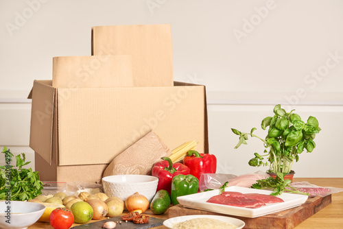 Box with packed meat vegetables on kitchen background. Food delivery services during coronavirus pandemic and social distancing. Shopping online. .Dinner delivery service.