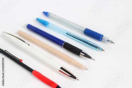 Pens of different colors and sizes on a white background