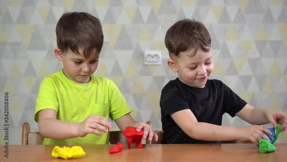 two Happy boy playing with plasticine. two Happy boy playing with plasticine.