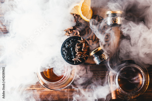 Foto Hookah tobacco in the clay bowl with cinnamon and anise stars, with thick smoke