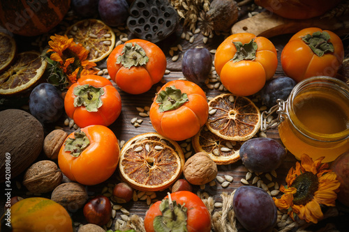 Pumpkins, persimmon, cereals, bread, seeds and nuts on a wooden background, Harvest, Autumn