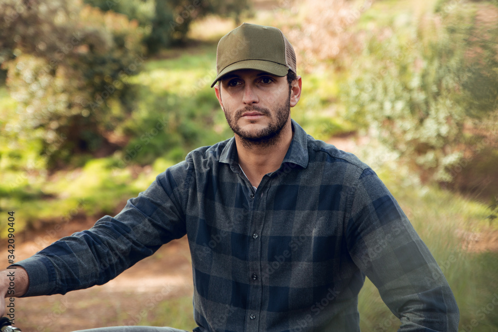 Mountain biking sportsman without protection sitting on bike in the middle of a forest looking away Mountain biking sportsman without protection sitting on bike in the middle of a forest looking away
