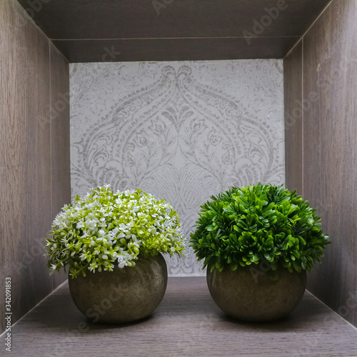 plantas con flores artificiales en hornacina de madera 