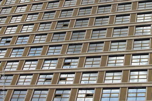 Modern office building facade with glass windows perpendicular lines close up, geometrical texture for background business, work