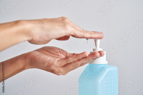 Woman cleaning her hands with alcohol antiseptic gel to prevent infection