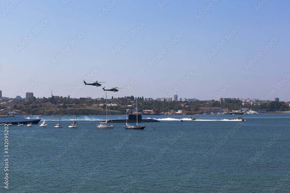 Mi-28 attack helicopters fly by at the parade in honor of Navy Day in Sevastopol Bay, Crimea
